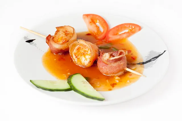 Bilde av ristede kongereker på spyd med saus og garnityr